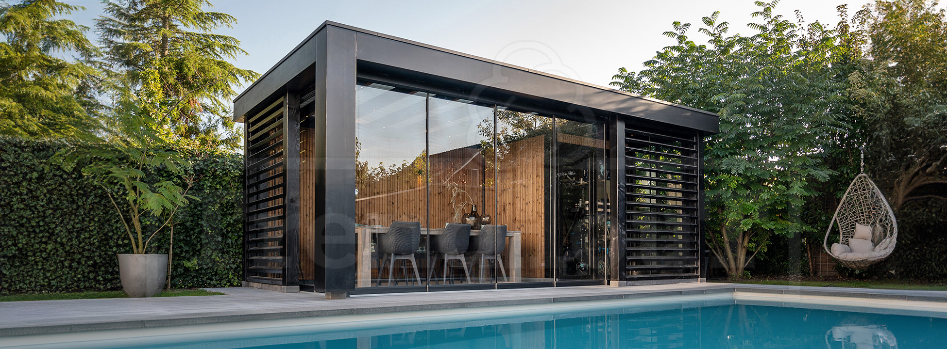 Moderne-zwart-houten-poolhouses-overkapping-met-technische-ruimte-bij-zwembad-met-glas-glazen-schuifdeuren